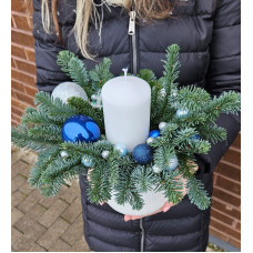 Christmas composition in a pot with one candle in blue tones